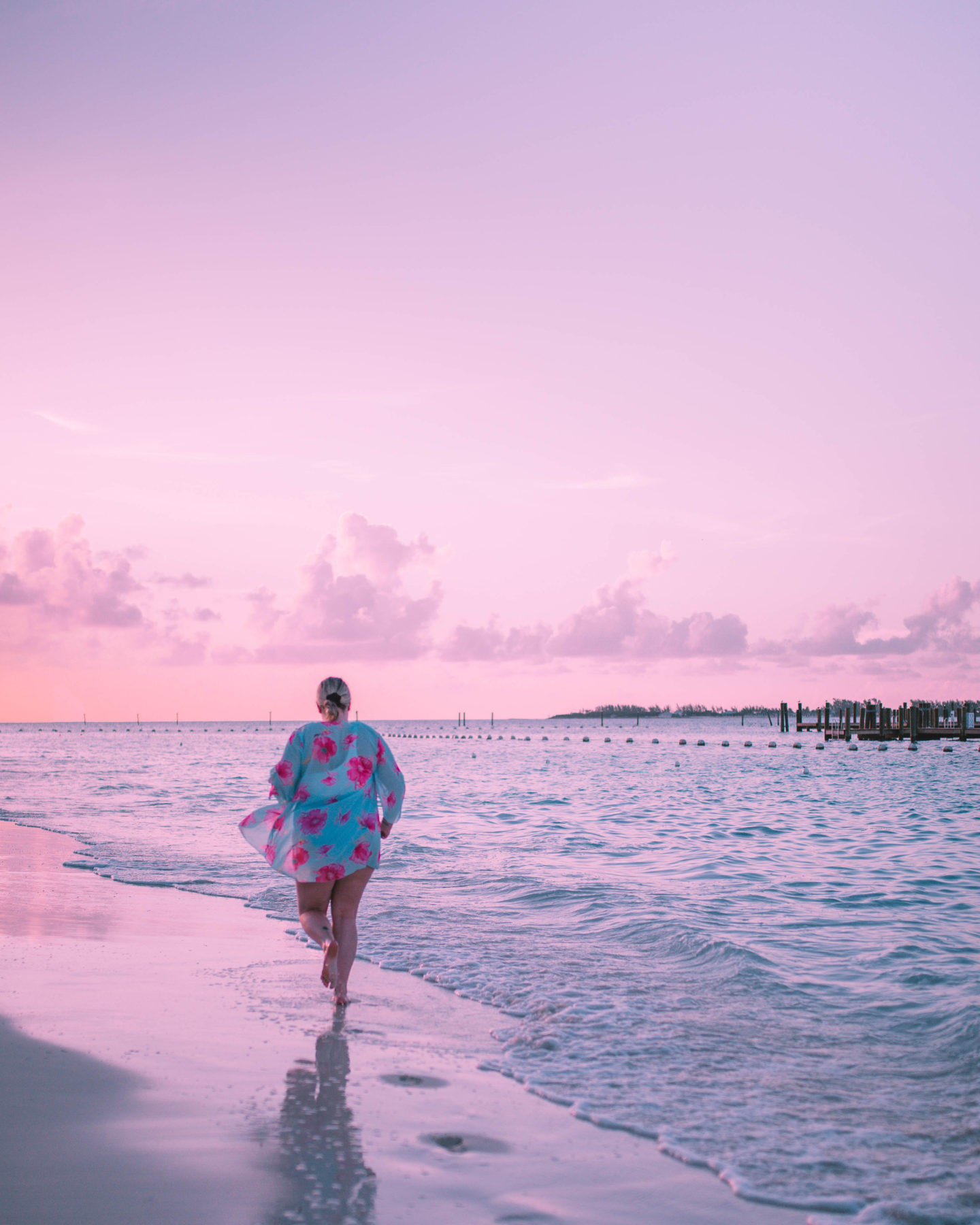 woman running off into sunset with cotton candy skies