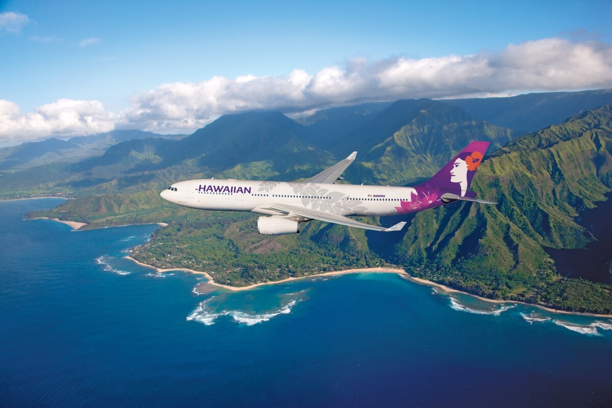 hawaiian airlines plane flying over stunning hawaii backdrop