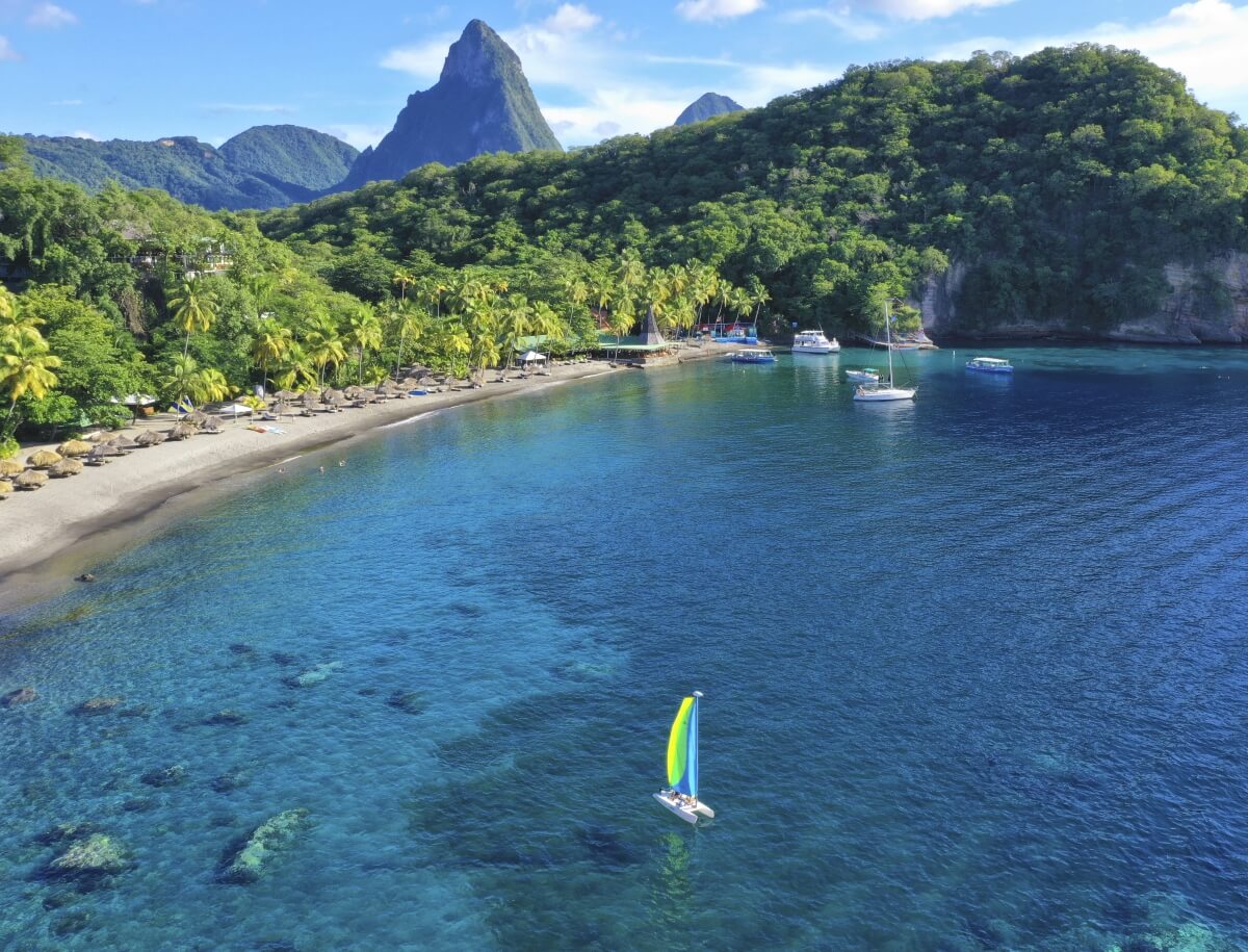 view of the beach and ocean with the pitons in the background at anse chastanet best all inclusive resorts in st lucia