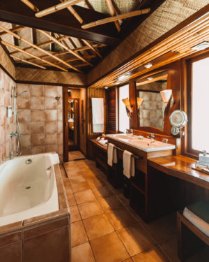 inside of the bathroom at the intercontinental bora bora le moana resort with dual sinks and separate bath tub and shower