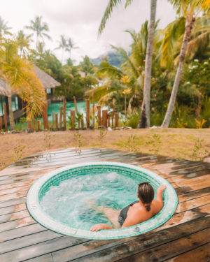 woman sitting in saltwater spa pool surrounded by lush greenery at spa in bora bora intercontinental thalasso