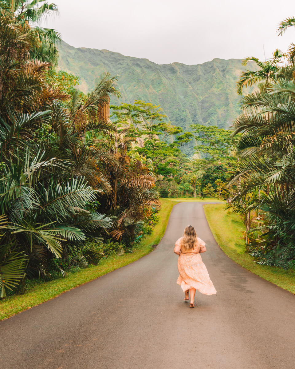 girl in dress running down road at botanical garden top things to do in oahu hawaii