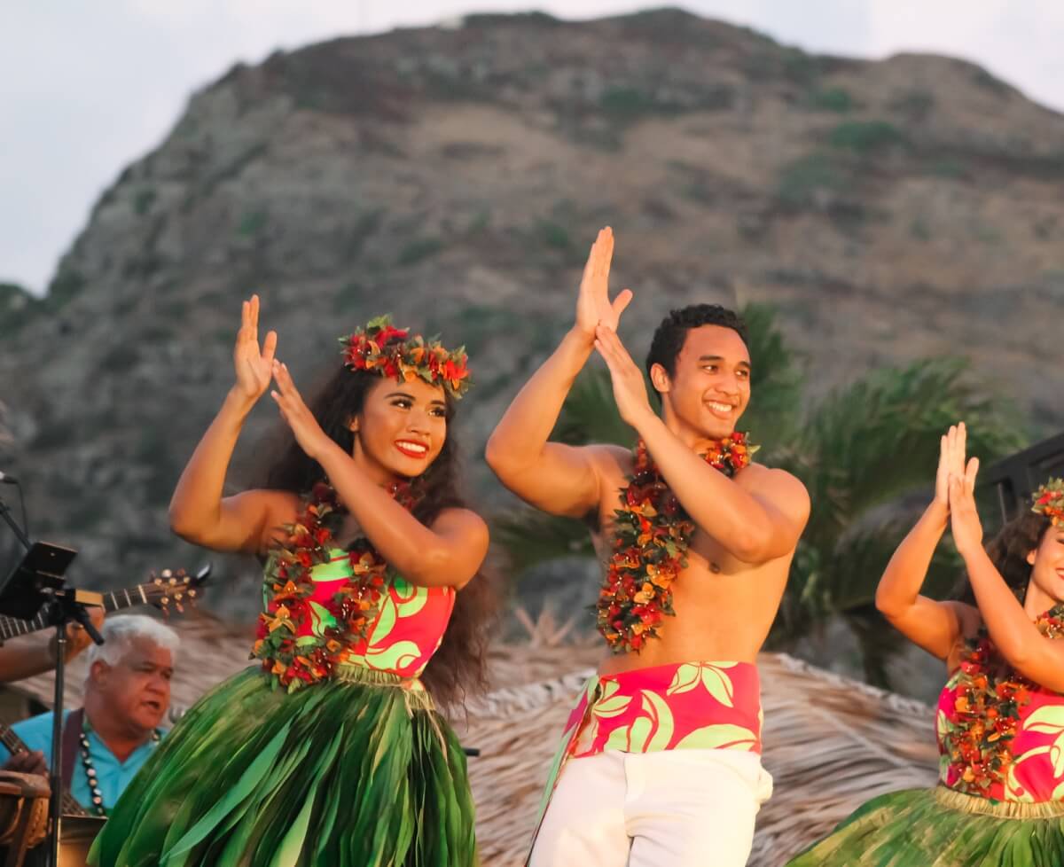 men and women in hawaii during a luau with traditional dress