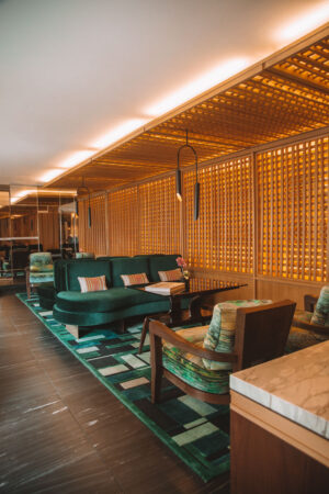 lobby area of four seasons bogota with warm lighting and deep green furniture and wood features