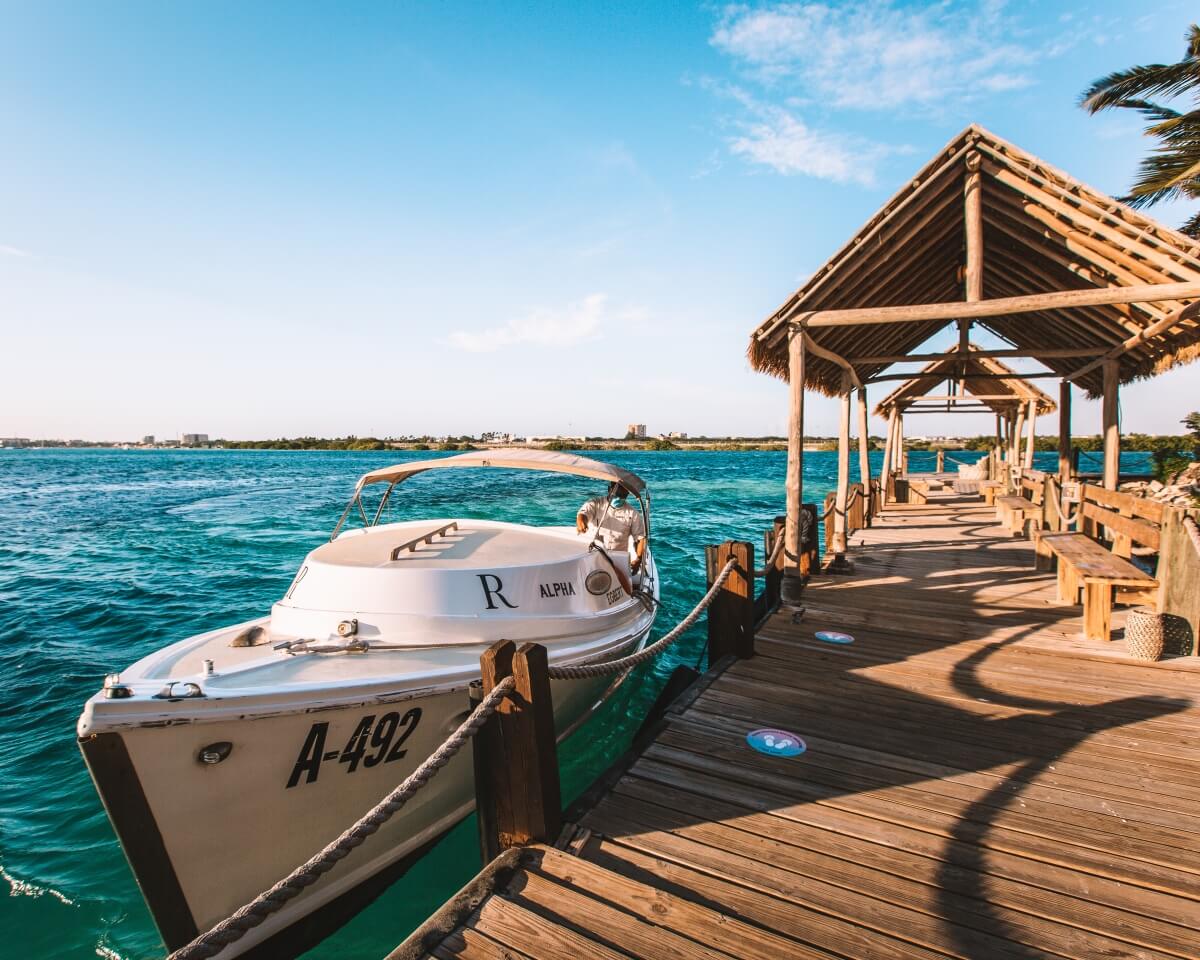 renaissance private island boat pulled up next to dock with blue water all around