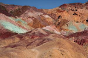 artists palette mountain range in death valley national park with mountains full of brown, orange, green, and red sands