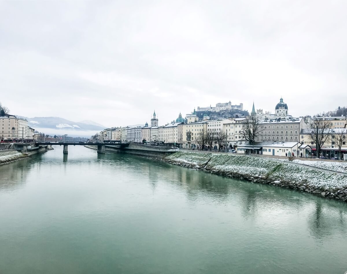 winter scenery of the river in salzburg austria in Europe, with a bridge in the distance and lots of classic buildings