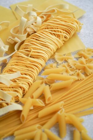 fresh pasta of all different types laid out on gray table