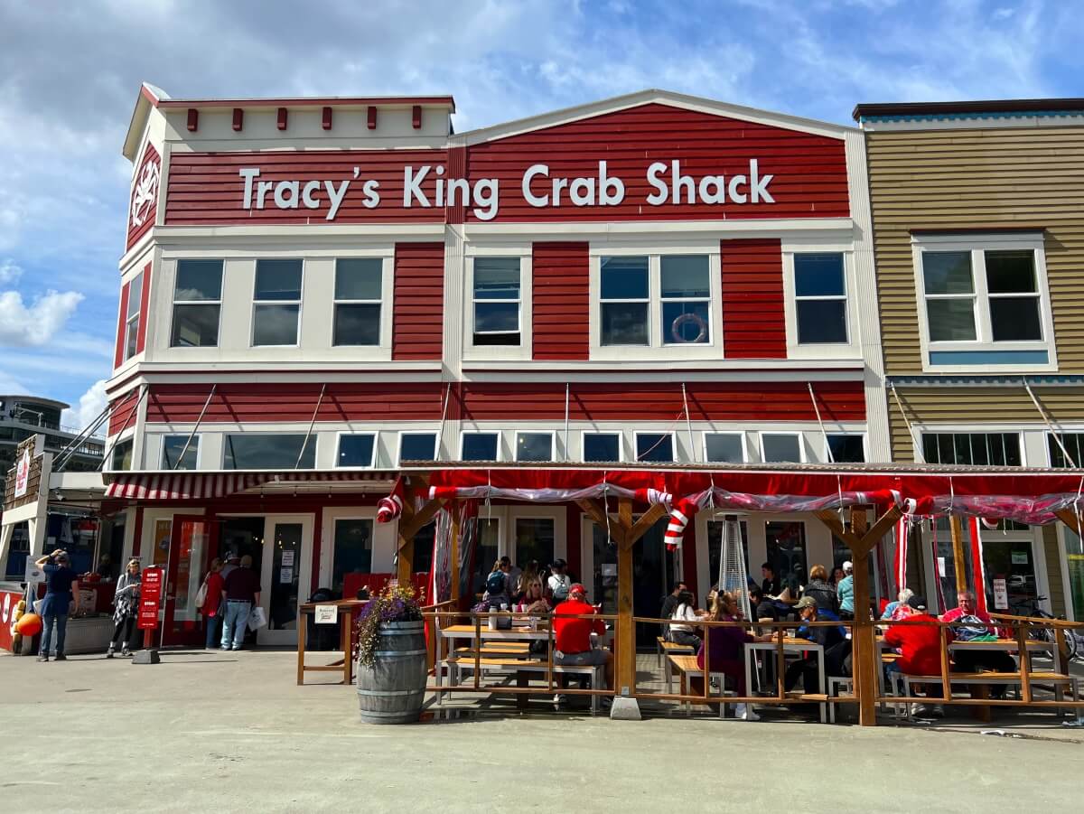 the bright red front of the restaurant called tracy's king crab shack at the Juneau cruise port in Alaska, with an outdoor seating area out 