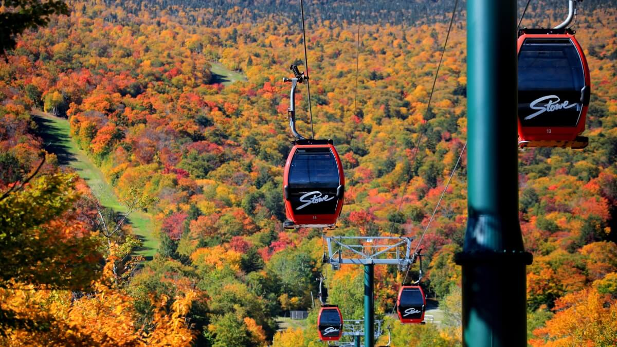 red gondola cars riding through the colorful fall foliage in Stowe VT