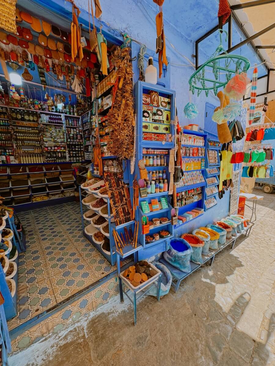 colorful spices and pigments decorating the blue wall of a shop in Chefchaouen Morocco