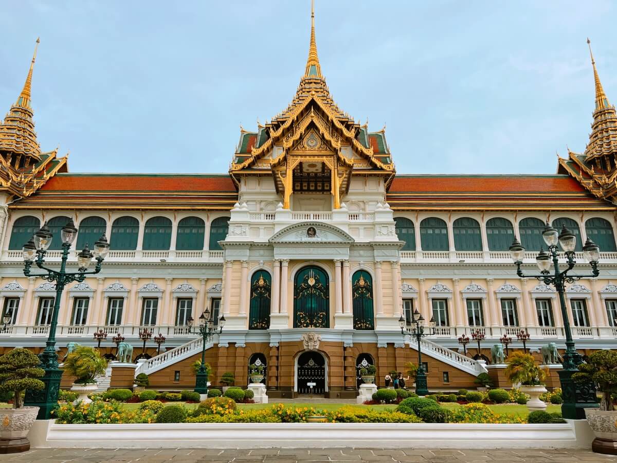 front view of one of the buildings of the Grand Palace in Bangkok, with unique Thai architecture and landscaping in front of the building